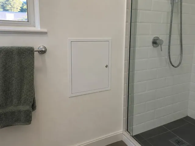 Neat white access panel on a bathroom wall beside a tiled shower in Dover Heights